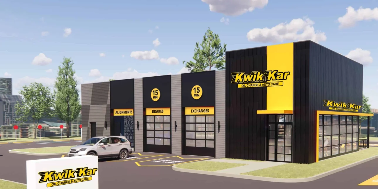 A Kwik Kar oil change and auto care building with a parking lot, a parked car, and clear signage on a sunny day.